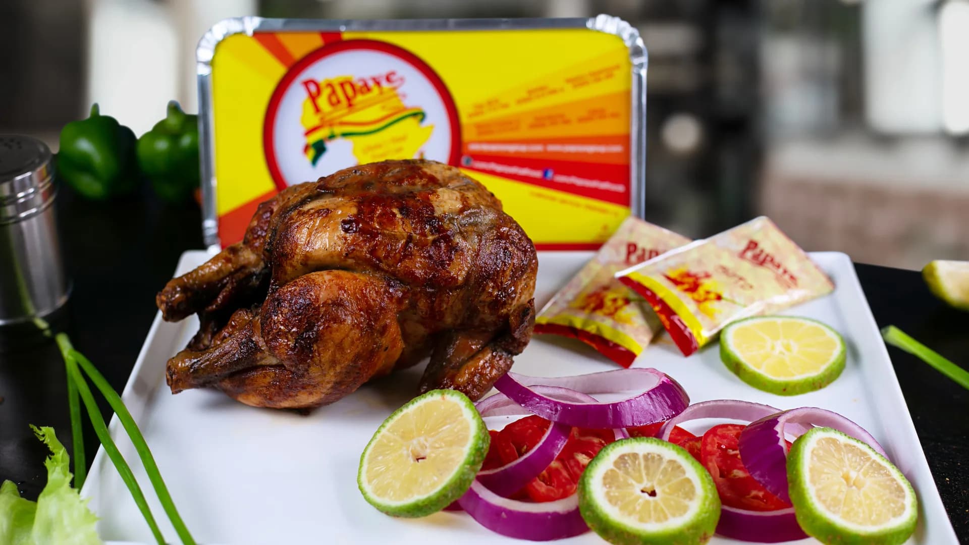 A Papaye roast chicken with lime, onion and tomato, in front of a Papaye box